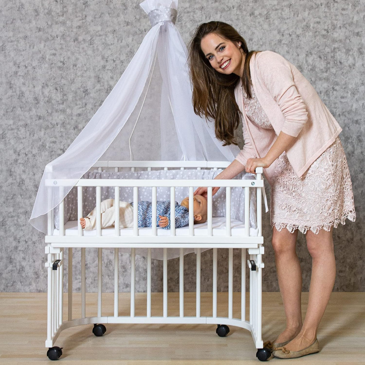 Oryginalne łóżeczko dostawne Babybay z litego drewna bukowego / kompaktowe i rozkładane / płynna regulacja wysokości łóżeczka i przyjazne dla środowiska / rośnie wraz z dzieckiem (lakierowane na biało) / w zestawie materac